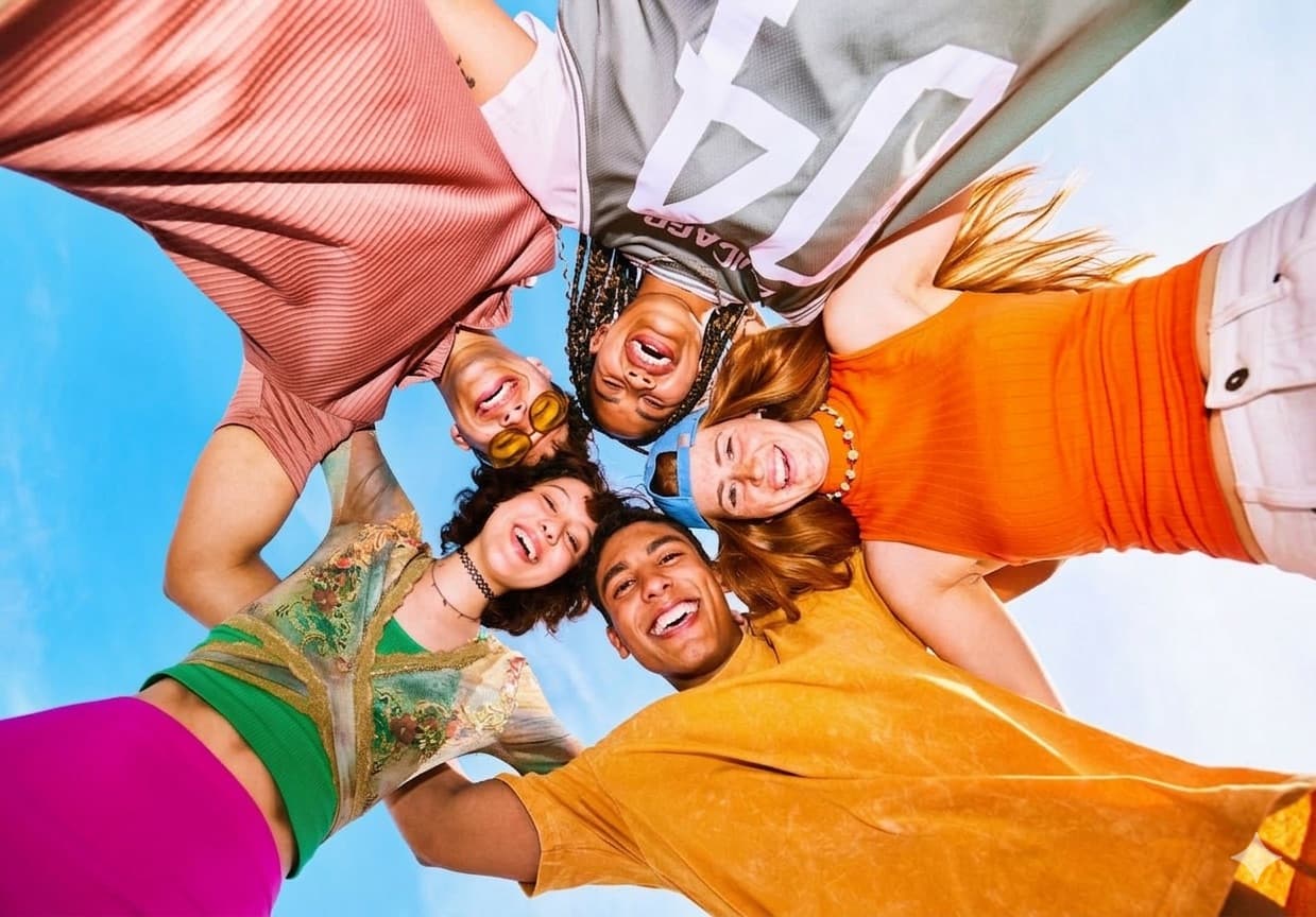 A group of diverse friends laughing and cheering together, capturing the social excitement and shared anticipation of a group lottery pool. The Joy of Shared Success in Lottery Pools